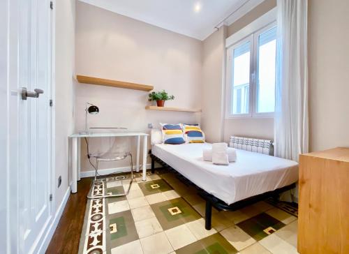 马德里Charming Blasco de Garay - Estancias Temporales的一间卧室配有一张床、一张书桌和一个窗户。