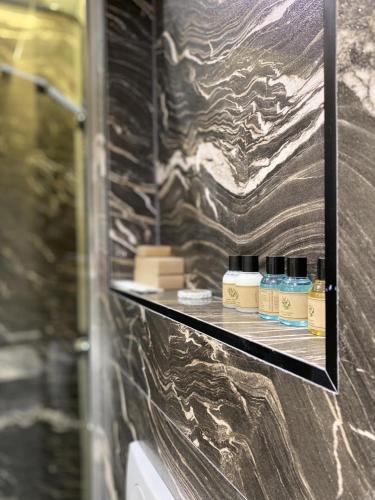 乌尔齐尼Marinus Hotel的浴室设有1个带4瓶肥皂的架子
