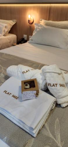 纳塔尔Flat Maravilhoso na praia - Ilusion Hotel的两张带白色毛巾和盒子的床