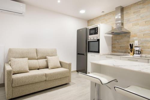 阿尔格达斯Apartamentos La Jasa的带沙发和炉灶的厨房 顶部烤箱