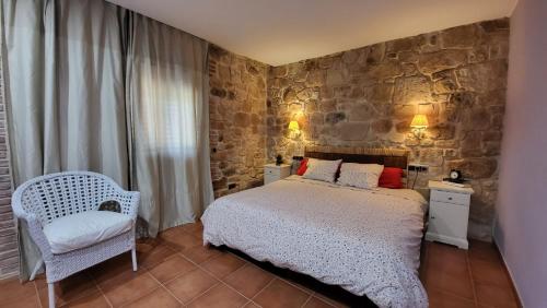 LledóMas De La Font的一间卧室设有一张床和石墙
