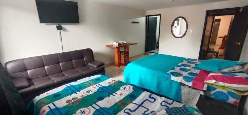 波哥大Casa Hotel Luna de Paso的一间带两张床和一张沙发的客厅