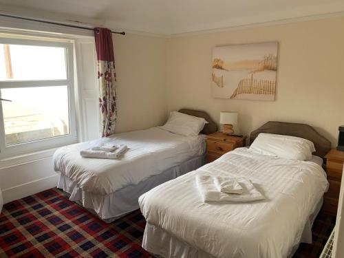 艾茅斯Cutty Sark Inn的一间卧室配有两张带毛巾的床