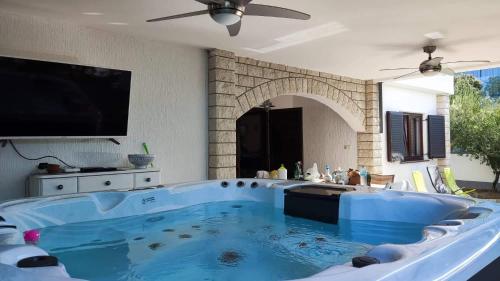 波弗加纳Villa Pagar - with jacuzzi - Renovated in 2022的客厅设有大型蓝色浴缸,配有电视