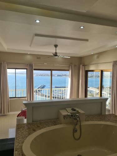 戈登湾Bikini Beach Manor的带浴缸的浴室,享有海景