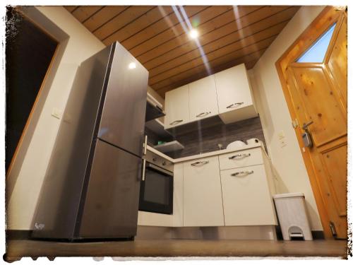 TrinCasa Mirada的厨房配有不锈钢冰箱和白色橱柜