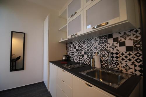 巴勒莫Le Cupole Design的厨房配有水槽和黑色台面