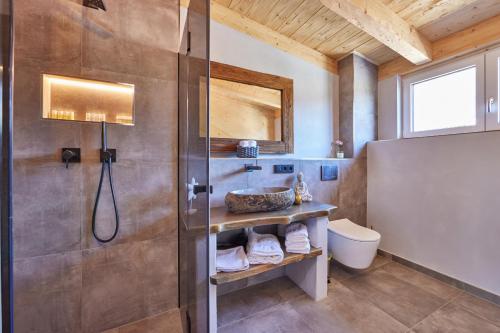 加尔米施-帕滕基兴Chalet Sunshine的带淋浴、盥洗盆和卫生间的浴室