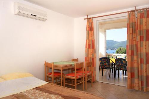 库希斯特Apartments by the sea Viganj, Peljesac - 10189的一间带桌椅的卧室和一个阳台