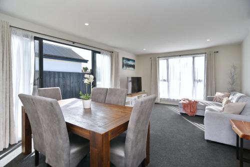 基督城Thomas Townhouse - Christchurch Holiday Homes的客厅配有木桌和椅子