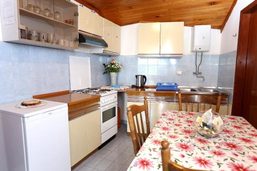 维甘Apartments by the sea Viganj, Peljesac - 10140的小厨房配有桌子和桌椅