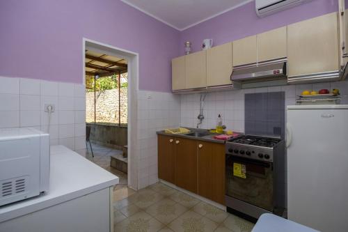 库希斯特Apartments by the sea Kuciste - Perna, Peljesac - 10142的厨房设有紫色墙壁和炉灶烤箱