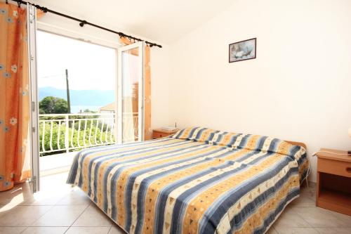 维甘Apartments by the sea Viganj, Peljesac - 10187的一间卧室设有一张床和一个大窗户