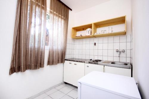 维甘Apartments by the sea Viganj, Peljesac - 10187的白色的小厨房,配有水槽和镜子
