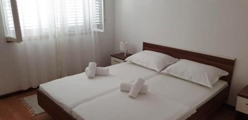 泰斯Seaside holiday house Nemira, Omis - 9504的一间卧室配有一张带两个白色枕头的床
