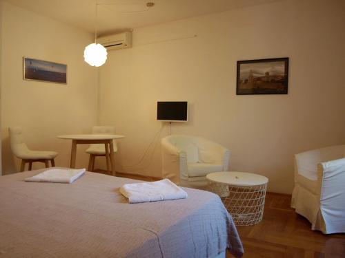 奥瑞比克Apartment Orebic 10153f的一间卧室配有一张床铺和椅子以及一台电视。