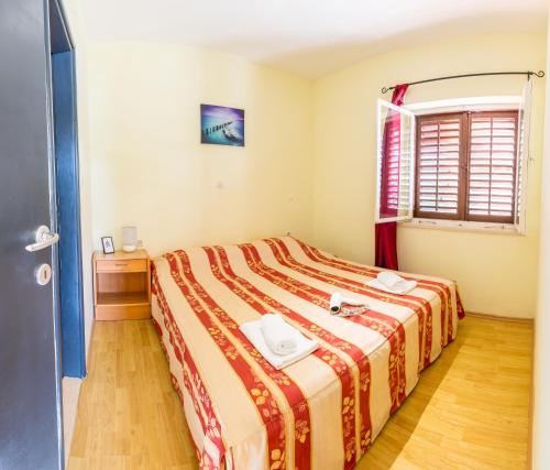 BrijestaApartment Zuronja 10134b的一间卧室配有一张带红色和黄色毯子的床