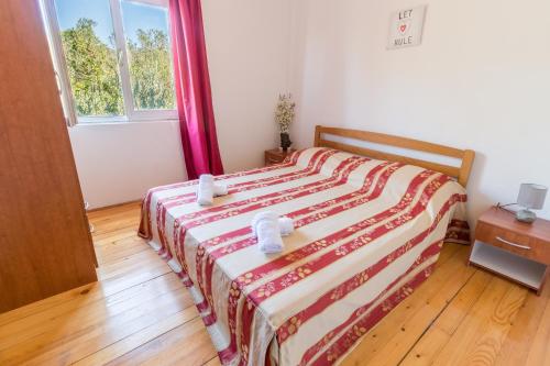 BrijestaApartments by the sea Zuronja, Peljesac - 10134的一间卧室配有一张带红白毯子的床