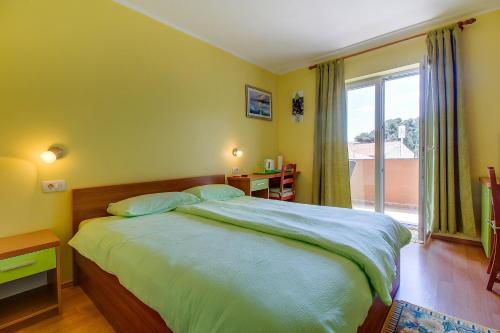 内里吉恩Apartments and rooms by the sea Nerezine, Losinj - 11815的一间卧室设有一张大床和一个大窗户