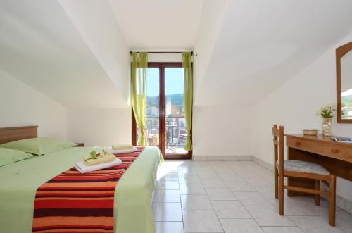 斯拉汀Apartments by the sea Slatine, Ciovo - 12176的一间卧室配有一张床、一张书桌和一个窗户。
