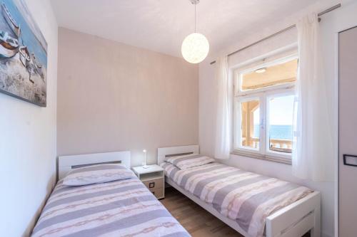 普利兹巴Apartments by the sea Cove Zaglav, Korcula - 12208的带窗户的客房内的两张床