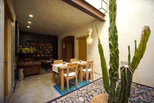 瓦哈卡市Casa Carmen Reforma的一间带桌子和仙人掌的用餐室