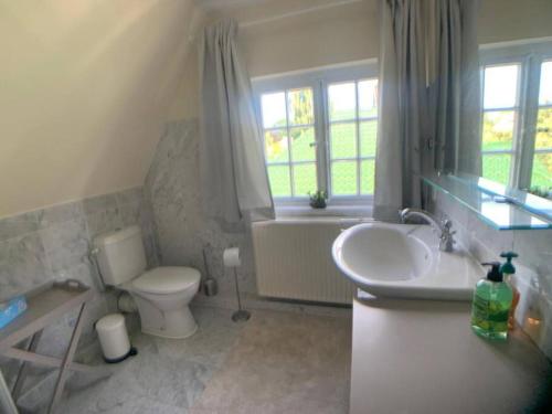 蒂门多弗施特兰德Top Lage! Charmantes Landhaus 5 Geh-Min v. Strand的浴室配有盥洗盆、卫生间和浴缸。