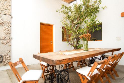 瓦哈卡市Casa Carmen Morelos的一张带椅子的木桌和花瓶