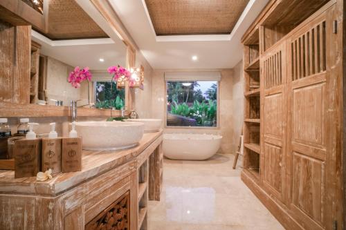 乌布Weda Cita Resort and Spa by Mahaputra的浴室配有2个盥洗盆和1个浴缸。