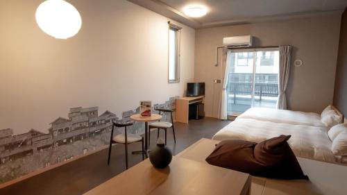 福冈Rakuten STAY Hakata Gion 302 - Rakuten Ichiba Collaboration Room -的卧室配有一张床和一张桌子及椅子