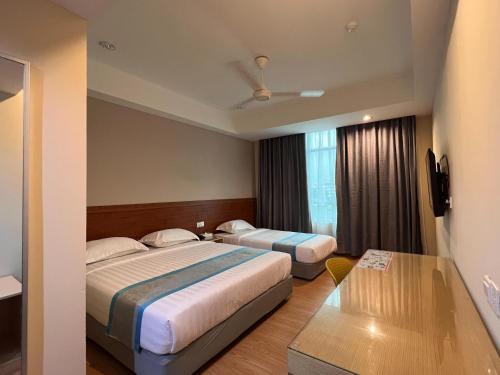伊纳南TD CAPITAL HOTEL的酒店客房设有两张床和窗户。