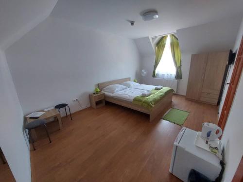 欧尔菲Csipke Vendégház的一间卧室配有一张床、一张桌子和一个窗户。