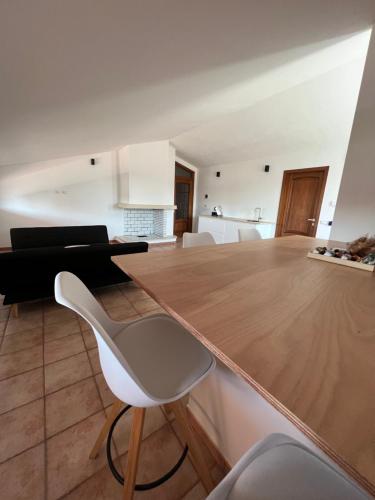 奥里斯塔诺B-Guest House的厨房配有木桌和白色椅子
