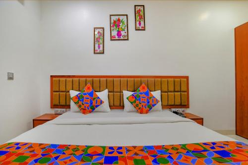 印多尔FabHotel Day2Day的一间卧室配有一张带色彩缤纷枕头的大床