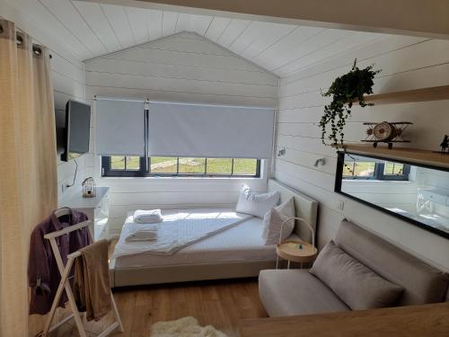 Jugureni1001 Village的一间卧室配有一张床、一张沙发和一个窗口