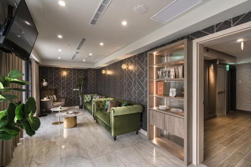 台北珂曼旅馆的客厅配有绿色沙发和桌子