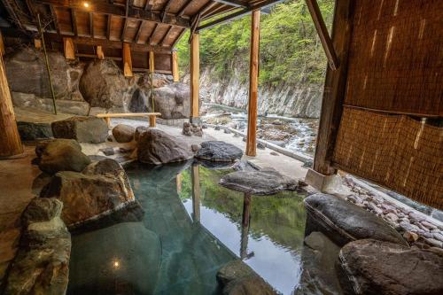 日光Nikko Nationalpark Kawamata Onsen KURA的岩石间里的一个大型水池