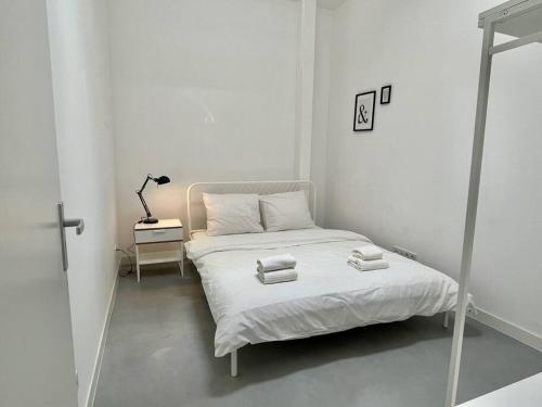 鹿特丹Trendy 2 Bedroom Serviced Apartment的白色卧室,配有带毛巾的床