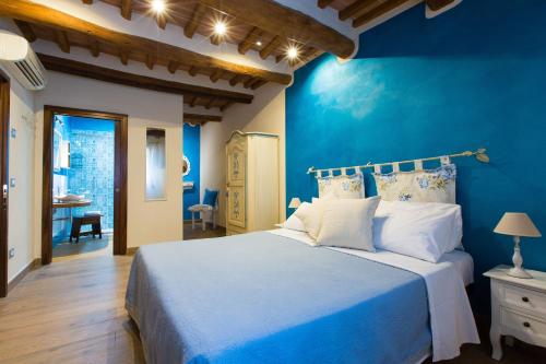 圣吉米纳诺Affittacamere Mainardi 16的蓝色的卧室,配有床和蓝色的墙壁