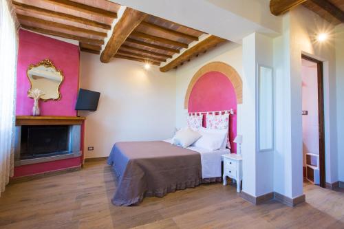 圣吉米纳诺Affittacamere Mainardi 16的一间卧室配有一张床和一个壁炉