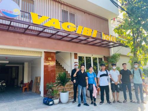 洞海Vagibi Hotel的一群站在酒店前的人