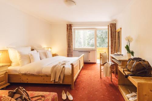 瓦尔奥纳的圣乔凡尼斯查晨公园酒店的一间卧室配有一张床、一张书桌和一个窗户。