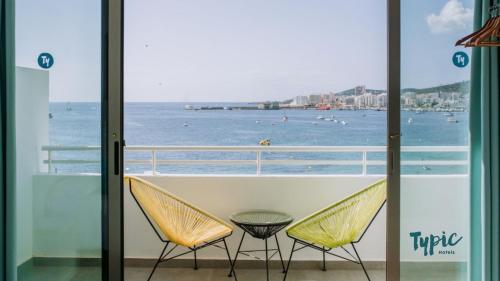 圣安东尼奥湾Typic Marina Playa - Adults Only的阳台配有两把椅子,享有海景。