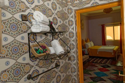 瓦尔扎扎特Riad Parfums de OUARZAZATE的浴室设有一面带镜子和毛巾的墙壁