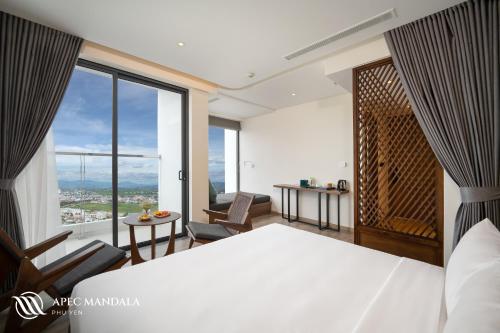 绥和市Mandala Hotel & Spa Phú Yên的一间卧室设有一张床和一个大窗户