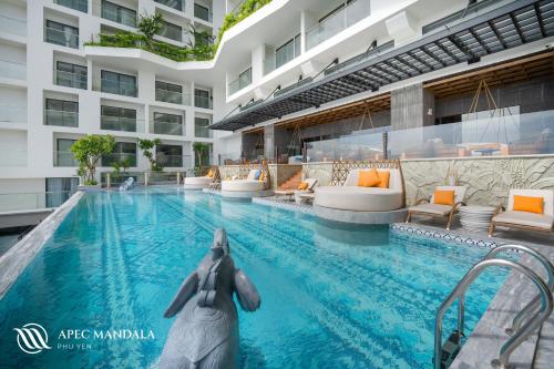 绥和市Mandala Hotel & Spa Phú Yên的一座建筑中间的一座带雕像的游泳池