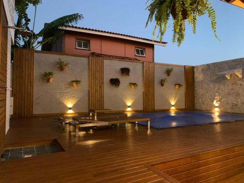 弗洛里亚诺波利斯Casa com piscina climatizada em frente à Praia do Santinho的墙上有长椅和灯的天井