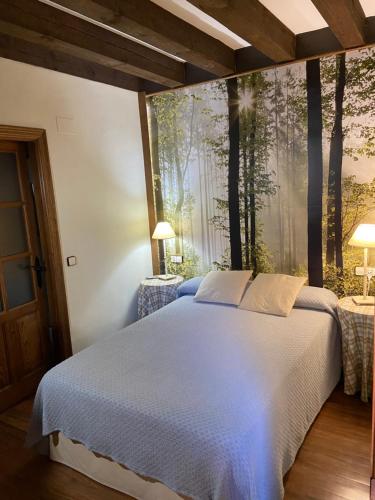 普韦布拉桑纳比亚橡树叶乡村民宿的卧室配有一张大床,墙上有树木