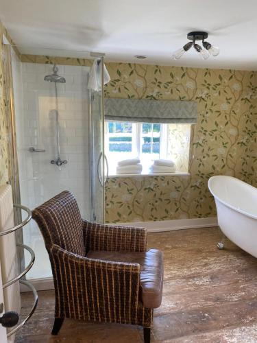 Weston SubedgeThe Seagrave Arms的一间带椅子、浴缸和窗户的浴室