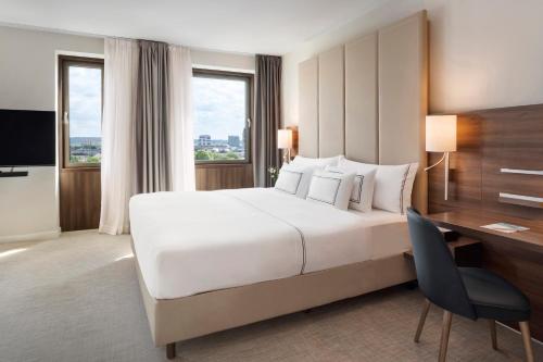 杜塞尔多夫杜塞尔多夫美利亚酒店的酒店客房设有一张大床和一张书桌。